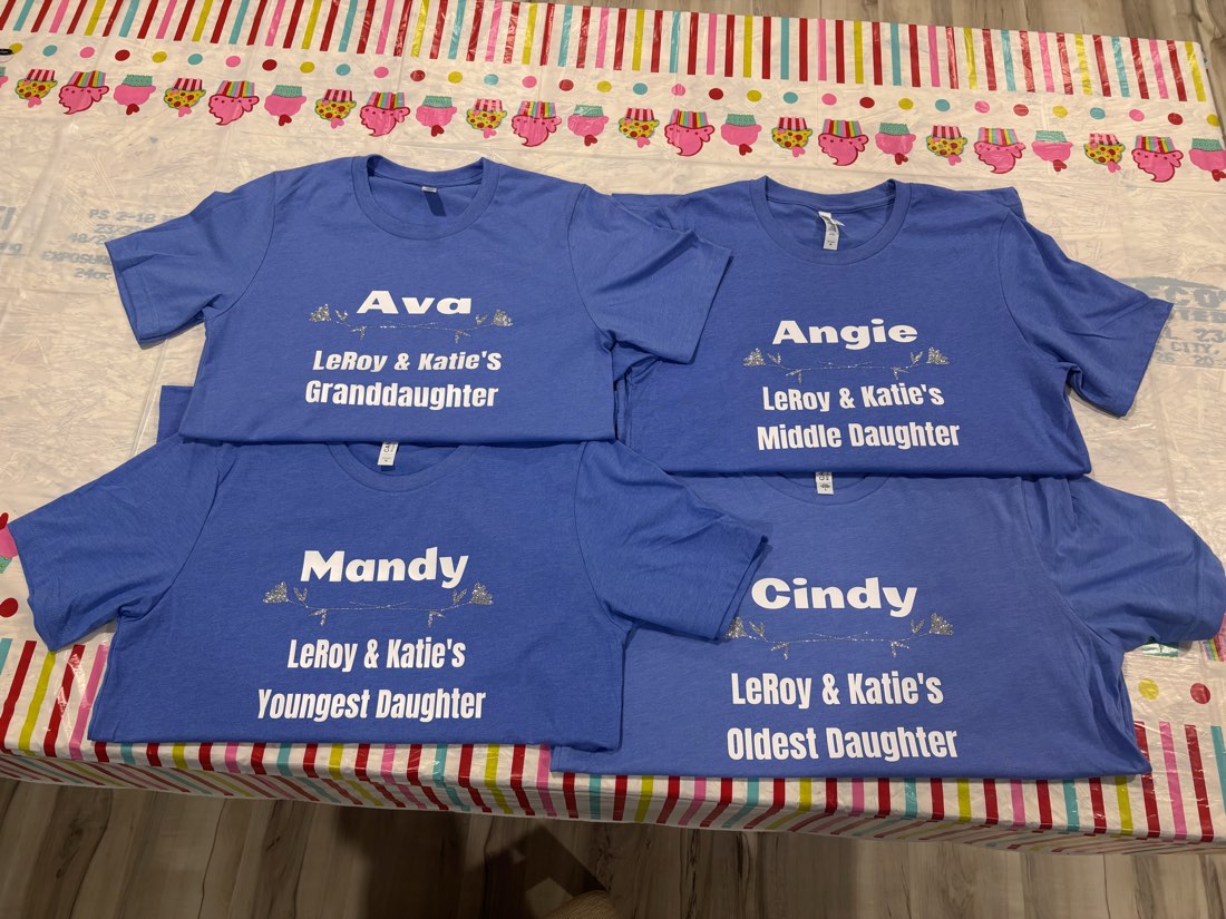 Matching personalized family shirts in blue laid out before a reunion