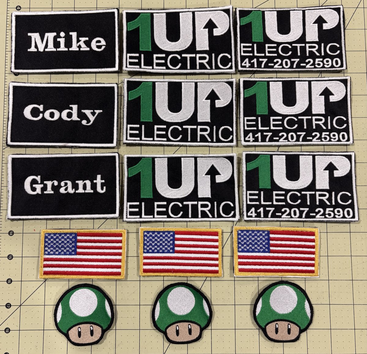 Embroidered company patches, name patches, and flag patches arranged on a cutting mat